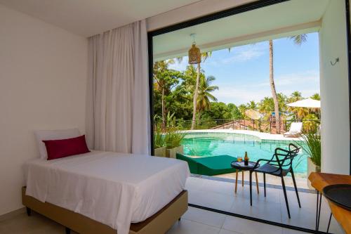 a bedroom with a bed and a view of a pool at Milie Lounge Pousada in Japaratinga