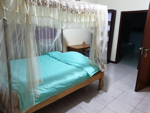 a bed with a canopy in a room at 3-Bedroom Mbarara Apartment with Optional Farm Tour in Mbarara