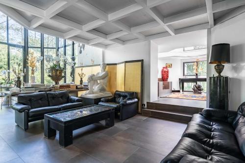 uma sala de estar com mobiliário de couro e uma lareira em Utopia home em Gif-sur-Yvette