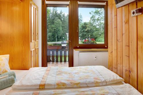 Schlafzimmer mit einem Bett vor einem Fenster in der Unterkunft Oskar in Titisee-Neustadt