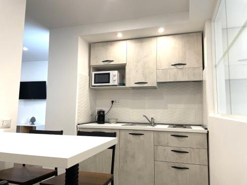 a small kitchen with a sink and a microwave at Maiolica Apartment in Caltanissetta