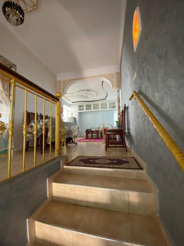 a staircase in a house with a yellow railing and a room at La casa de Halima in Sidi Ifni