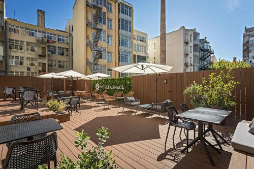 a patio with tables and chairs and umbrellas at Hotel Canada in Lisbon