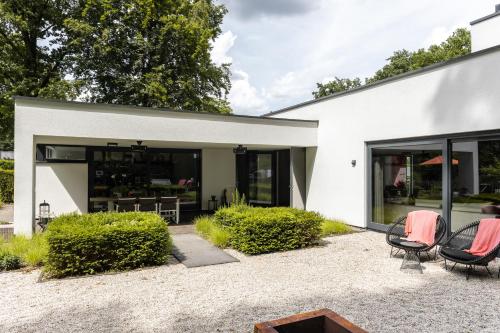 a white house with chairs and tables in front of it at Avellano in Helmond