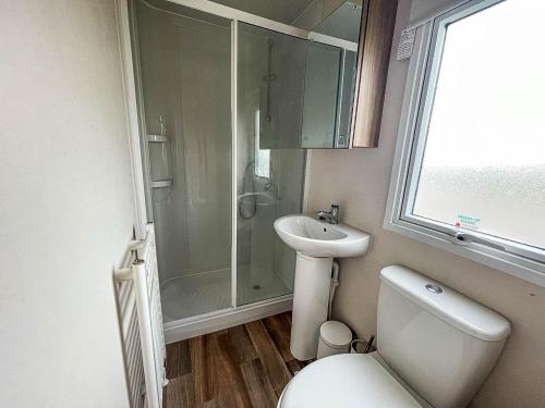 a bathroom with a toilet and a shower and a sink at Superb 6 Berth Caravan At Martello Beach, Near Clacton-on-sea Ref 29008mc in Clacton-on-Sea