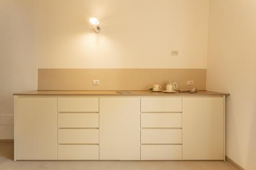 a kitchen with white cabinets and a counter top at Nido di Gemma in Ispra