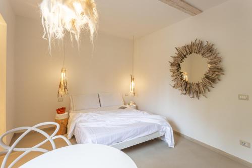 a white bedroom with a bed and a mirror at Nido di Gemma in Ispra