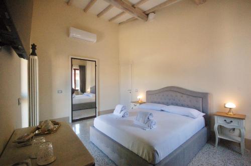 sypialnia z dużym białym łóżkiem i stołem w obiekcie Residenza d'Epoca CAVALIERE w mieście Bibbona