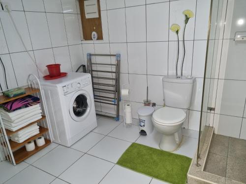 a bathroom with a washing machine and a toilet at Jan thiel in Jan Thiel