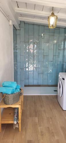 uma casa de banho com paredes em azulejos azuis e uma máquina de lavar roupa em Villa Alicante Sunbeach em El Campello