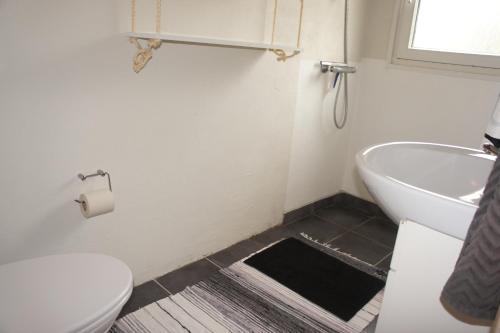 a bathroom with a tub and a toilet and a sink at (id 081) Åbakken 19 in Esbjerg