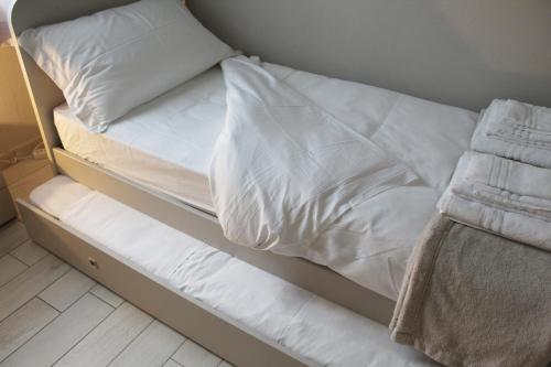 an unmade bed with white sheets and pillows on it at Bene39 in Turin