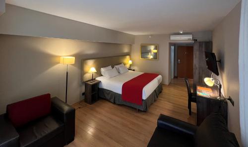 um quarto de hotel com uma cama e um sofá em Bue Hotel em Buenos Aires