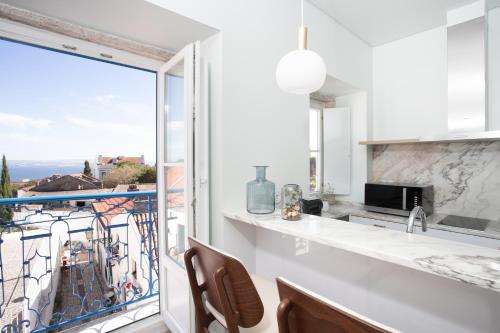 a kitchen with a balcony with a large window at Hermitage Castelo - Casa Saint Jorge in Lisbon