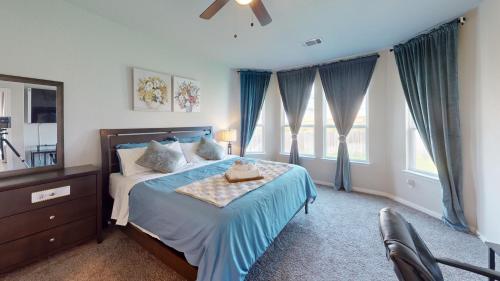 a bedroom with a bed and a dresser and windows at Luxury Lovely Comfort house in San Antonio