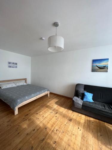 a living room with a bed and a couch at Amazing view apartment in Jelgava