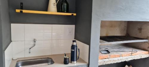 eine Küche mit einem Waschbecken und einer Flasche Wein in der Unterkunft Nuestra Casa en Paso in Paso de la Patria