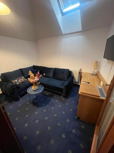 a living room with a couch and a table at Hotel Apollon in Litoměřice