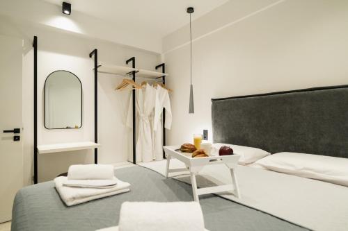 a bedroom with a bed and a table and a mirror at Noema Urban Living in Heraklio
