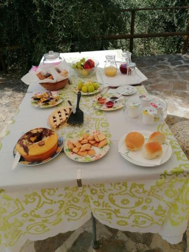 ein weißer Tisch mit Tellern voller Essen darauf in der Unterkunft Casa La Lamia B&B in Perdifumo