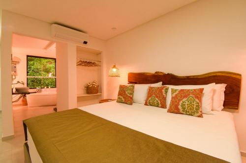 a bedroom with a large bed and a bathroom at Milie Lounge Pousada in Japaratinga
