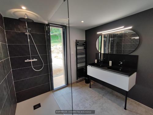a bathroom with a sink and a shower with a mirror at VIP REFUGE in Cazillac