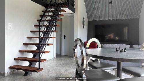 a spiral staircase in a living room with a table at VIP REFUGE in Cazillac