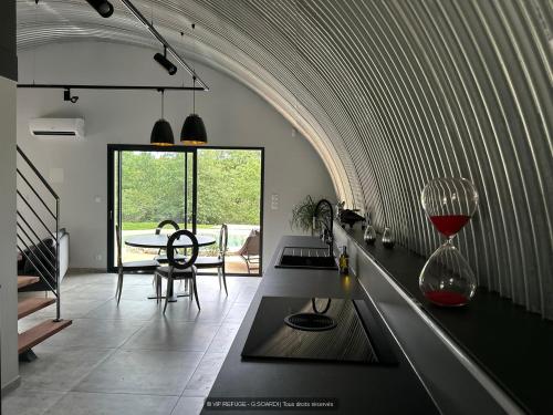 a kitchen with a table with a wine glass at VIP REFUGE in Cazillac