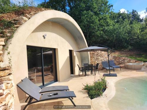 a patio with chairs and an umbrella next to a pool at VIP REFUGE in Cazillac