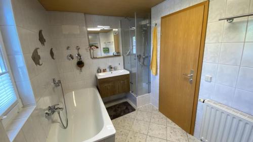 a bathroom with a tub and a shower and a sink at Gohrischblick in Kurort Gohrisch