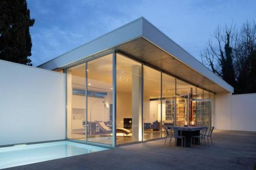 a glass house with a table in front of it at Casa Briteiros in Guimarães