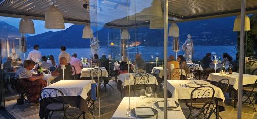 a group of people sitting at tables in a restaurant at Hotel Meridiana in Bellano
