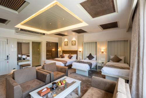 a hotel room with two beds and a living room at Hotel Grand Boulevard Dal Lake View Srinagar in Srinagar