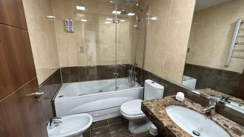 a bathroom with a toilet and a tub and a sink at Vitania Resort La Cala Apartment in Málaga