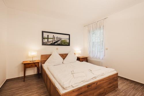 sypialnia z łóżkiem z białą pościelą i oknem w obiekcie Küstenhostel w mieście Klausdorf (Meklemburgia-Pomorze Przednie)