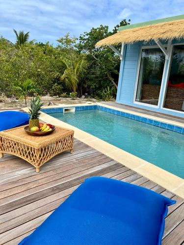 a table and chairs on a wooden deck next to a pool at Villa Branca - Les Terres Basses in Marigot