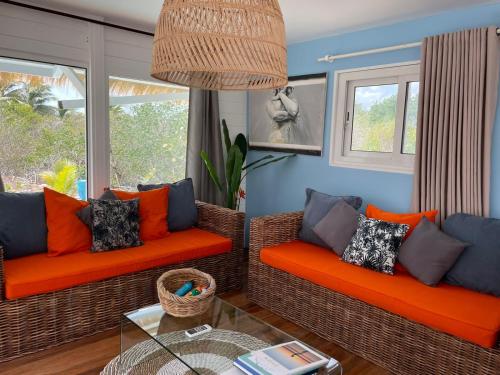 a living room with two couches and a glass table at Villa Branca - Les Terres Basses in Marigot