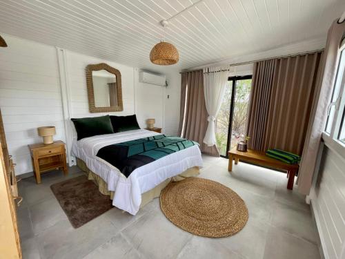 a bedroom with a bed and a large window at Villa Branca - Les Terres Basses in Marigot