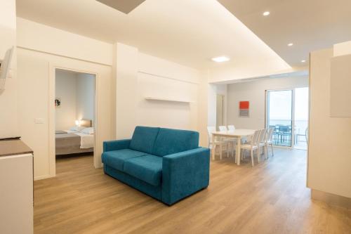 a living room with a blue chair and a bedroom at Villa Mare Pineto in Pineto