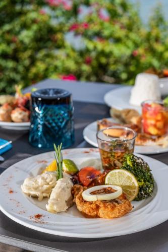 a table with plates of food on a table at Zenitude Hôtel Résidences Le Salako in Le Gosier