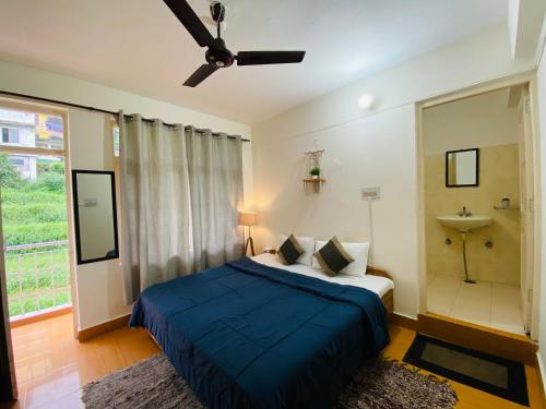a bedroom with a bed and a ceiling fan at Rahgir Mcleodganj in McLeod Ganj