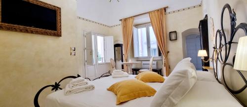 una camera da letto con un grande letto bianco con cuscini gialli di Palazzo Castiglione a Gallipoli