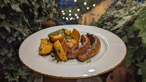 a plate of food with sausage and potatoes on it at Hotel Kartli in Tbilisi City