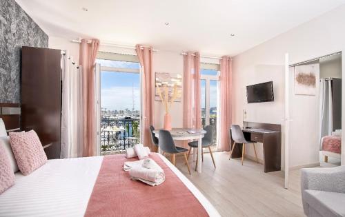 サン・ラファエルにあるHotel du Vieux Portのベッドルーム1室(大型ベッド1台、デスク、テーブル付)