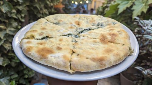 a pizza sitting on a plate on a table at Hotel Kartli in Tbilisi City