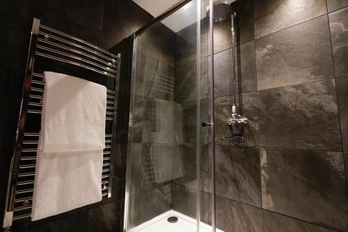a bathroom with a shower with a glass door at Ruthin Castle Hotel and Spa in Ruthin