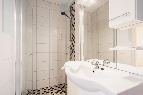 a white bathroom with a sink and a shower at Küstenhostel in Klausdorf Mecklenburg Vorpommern