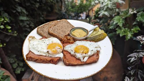 a plate of eggs and bread with pickles and mustard at Hotel Kartli in Tbilisi City