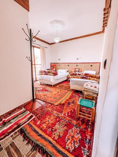 a room with two beds and a rug at Gite Panorama in Imlil