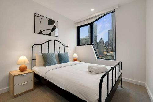 1 dormitorio con cama grande y ventana grande en Bright 2B apt next to Flagstaff Garden freeparking#FG1003, en Melbourne